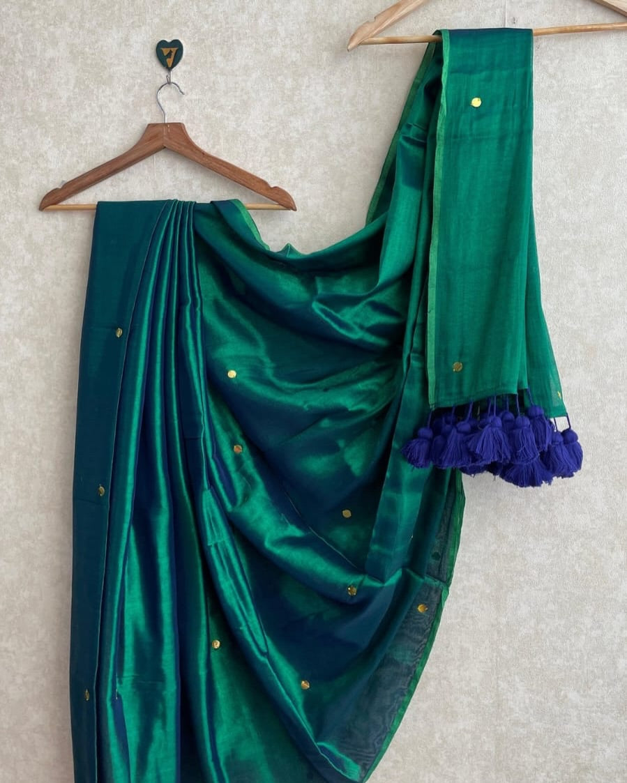 Green saree with matching blouse on a hanger against a light background